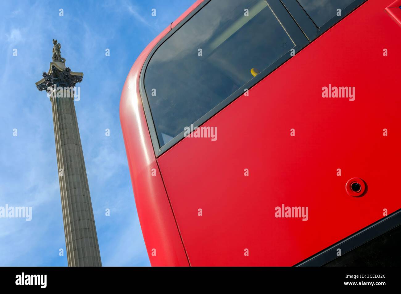 Londra, Inghilterra - Un autobus rosso di Londra passa accanto alla colonna di Nelson in Trafalgar Square nel centro di Londra. Foto Stock