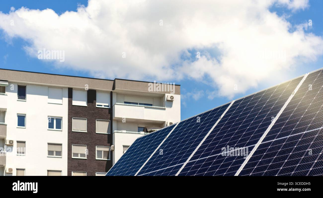 Costruzione e sviluppo sostenibili. Nuovo grande pannello solare con casa residenziale sullo sfondo Foto Stock