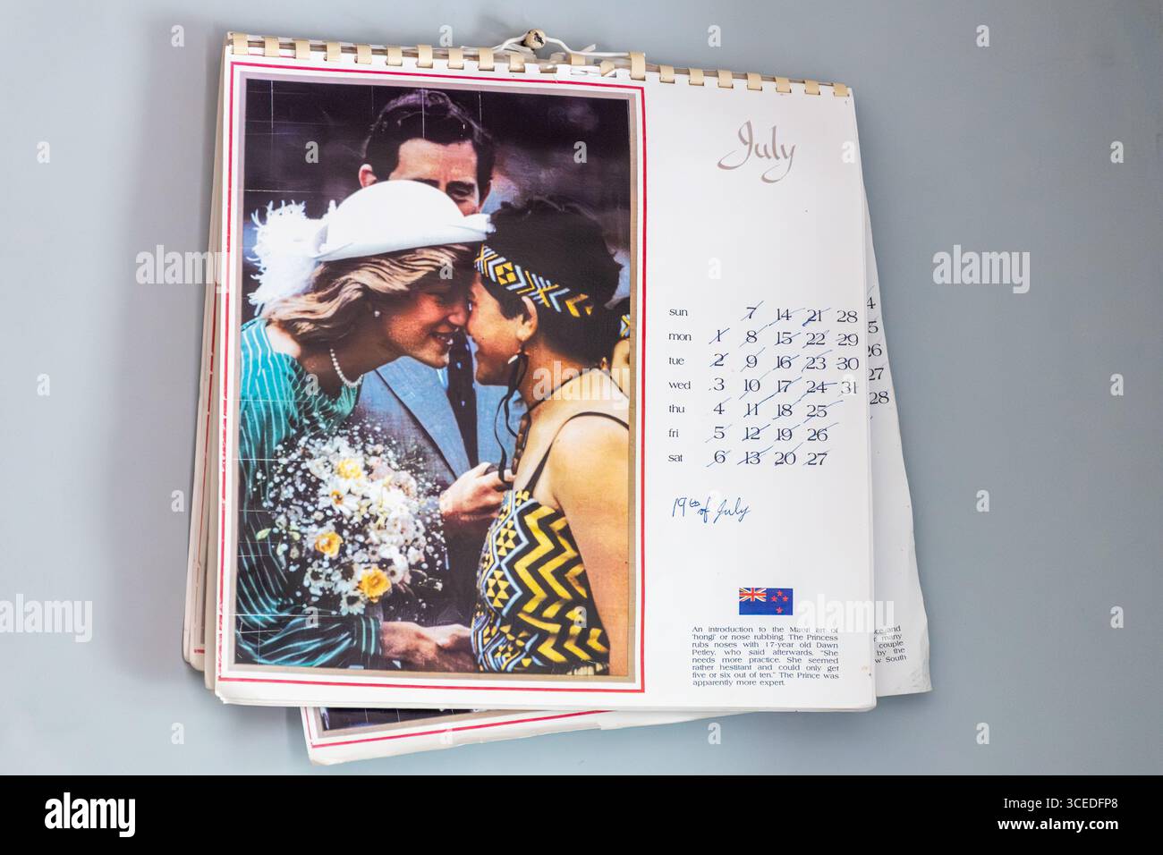 Il vecchio calendario murale degli anni '1980 si aprì per mostrare una fotografia dell'allora Principe Carlo e della defunta Principessa Diana in una visita reale in nuova Zelanda con un maori Foto Stock