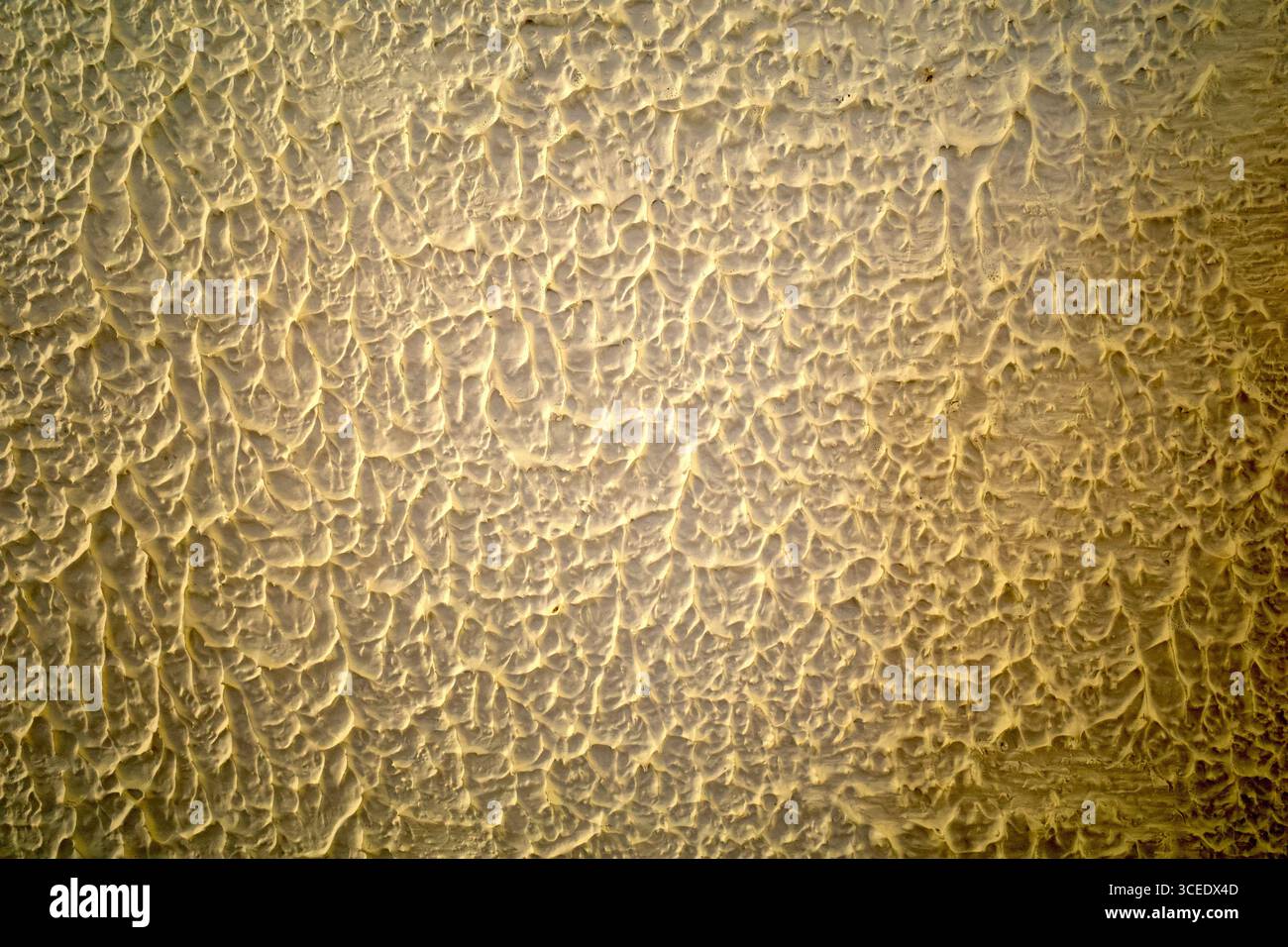 Parete in cemento dorato per interni, carta da parati o sfondo con texture artistiche. Foto Stock