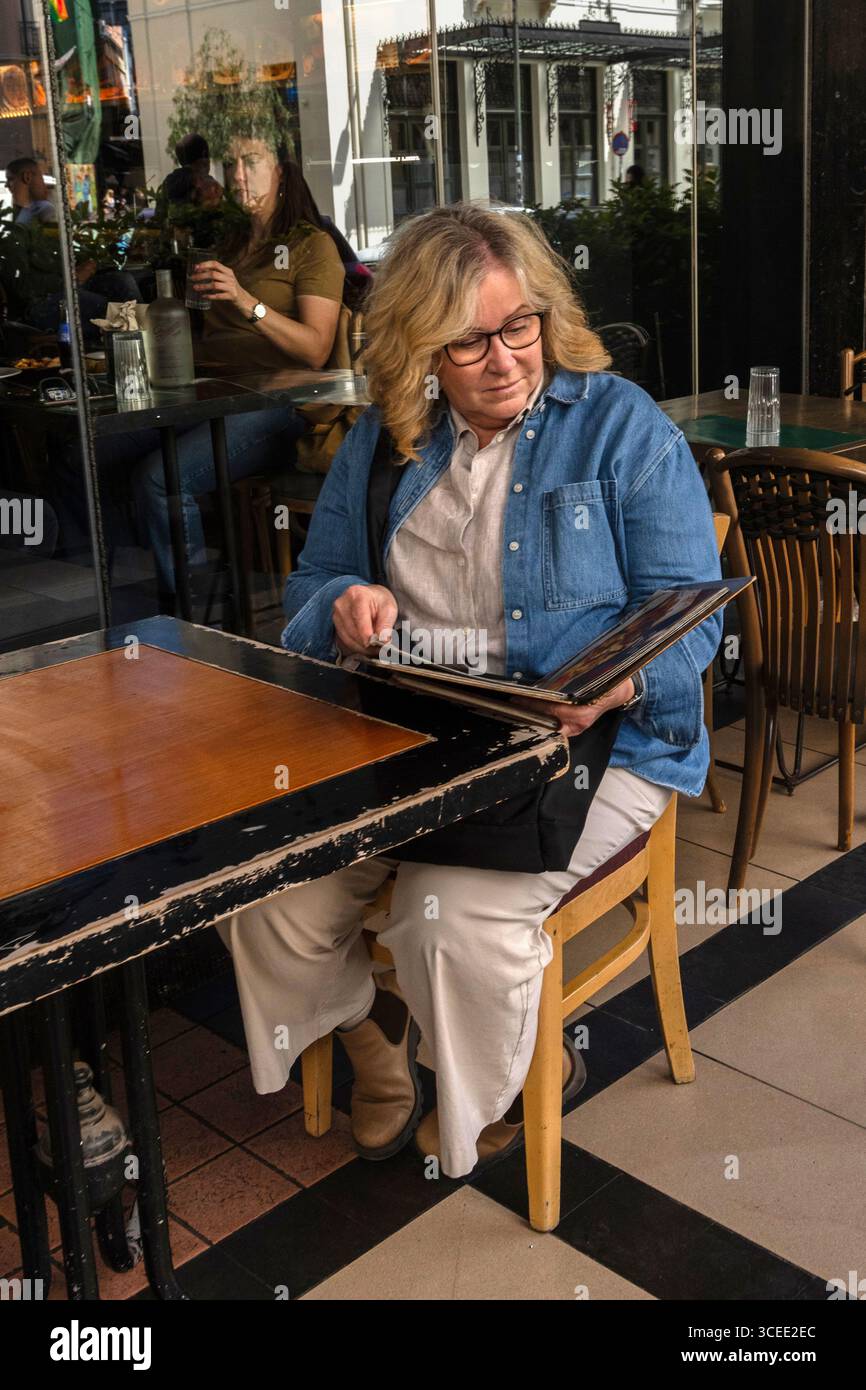 Donne che leggono il menu fuori da una taverna ad Atene, Grecia Foto Stock