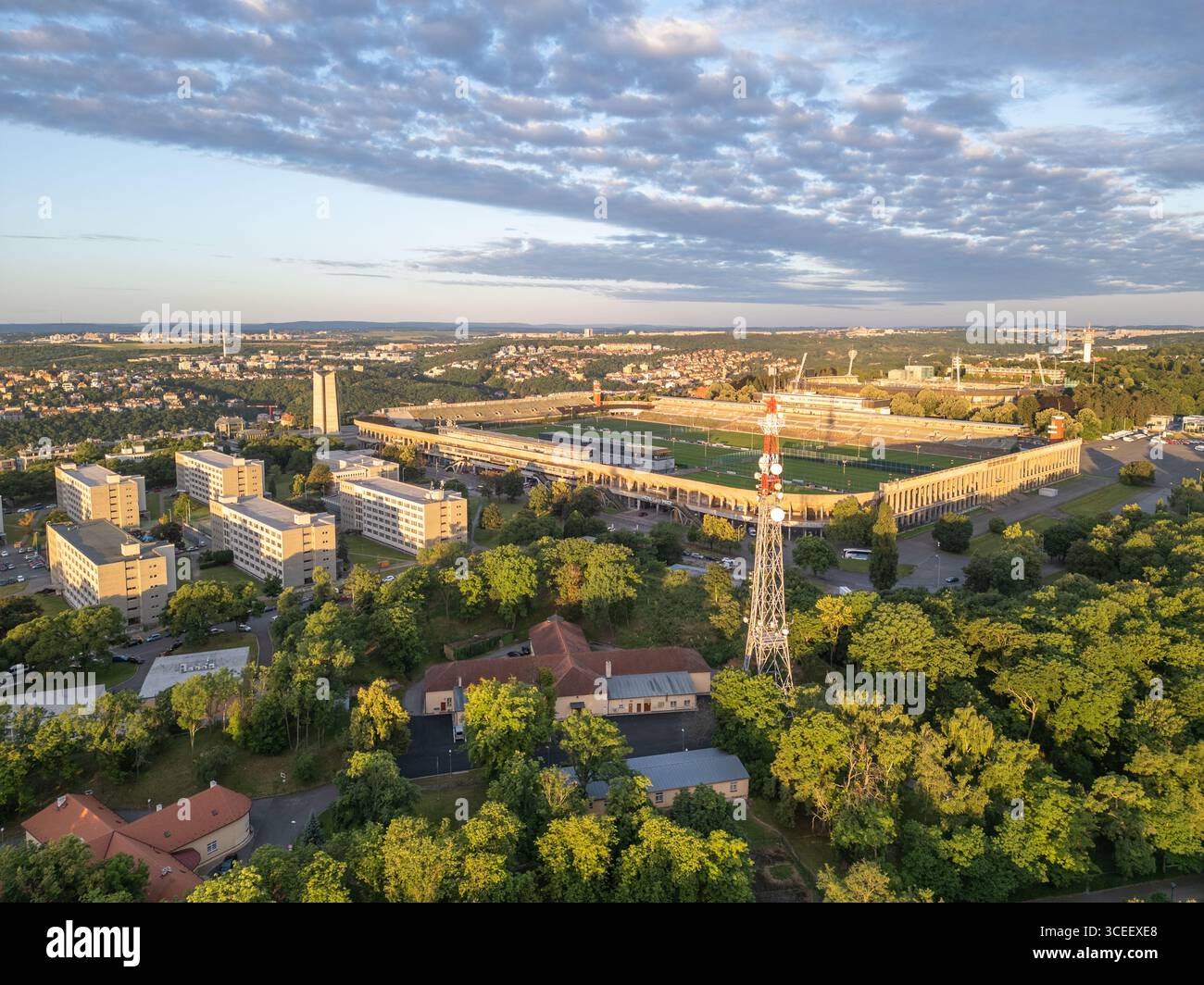 Lo stadio Strahov di Praga è raffigurato sullo sfondo di un bellissimo cielo crepuscolo. Il verde circostante e l'architettura urbana creano una splendida prospettiva aerea. Foto Stock