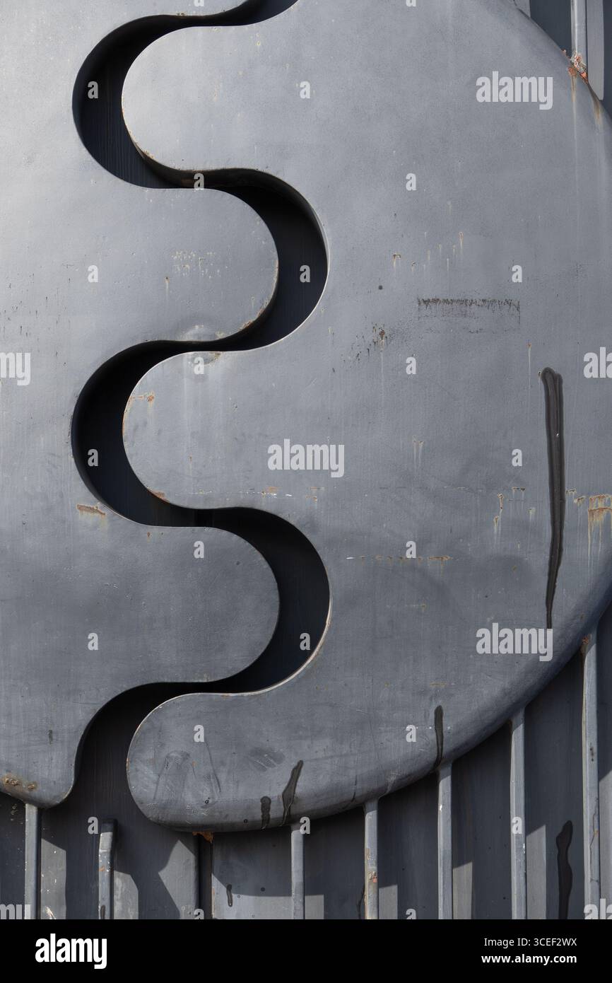 metallo ondulato ricavato da una parete in metallo cromato argentato ombra a forma di s a separazione di due lati ondulati tra due parti di spessa materi metallici Foto Stock