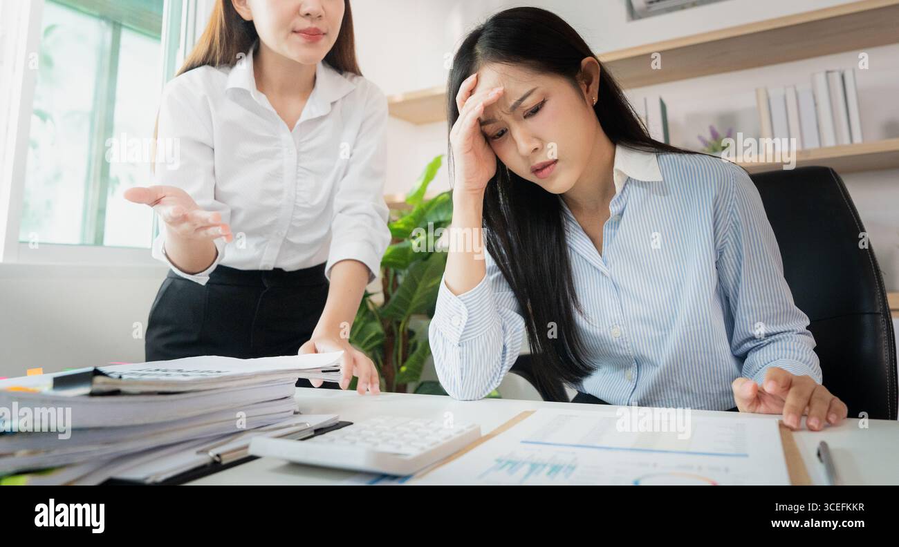 Stress sul luogo di lavoro. Dipendente che soffre di ansia durante un incontro teso con il manager. Foto Stock