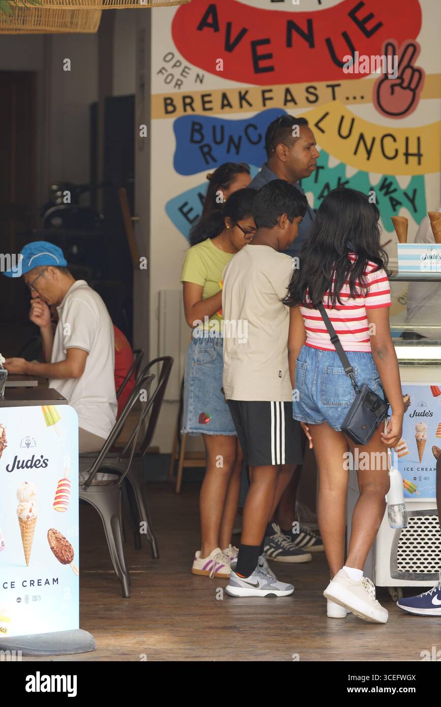 Persone che amano gelati in un caffè con interni colorati. Stivaggio-on-the-Wold, Inghilterra Foto Stock