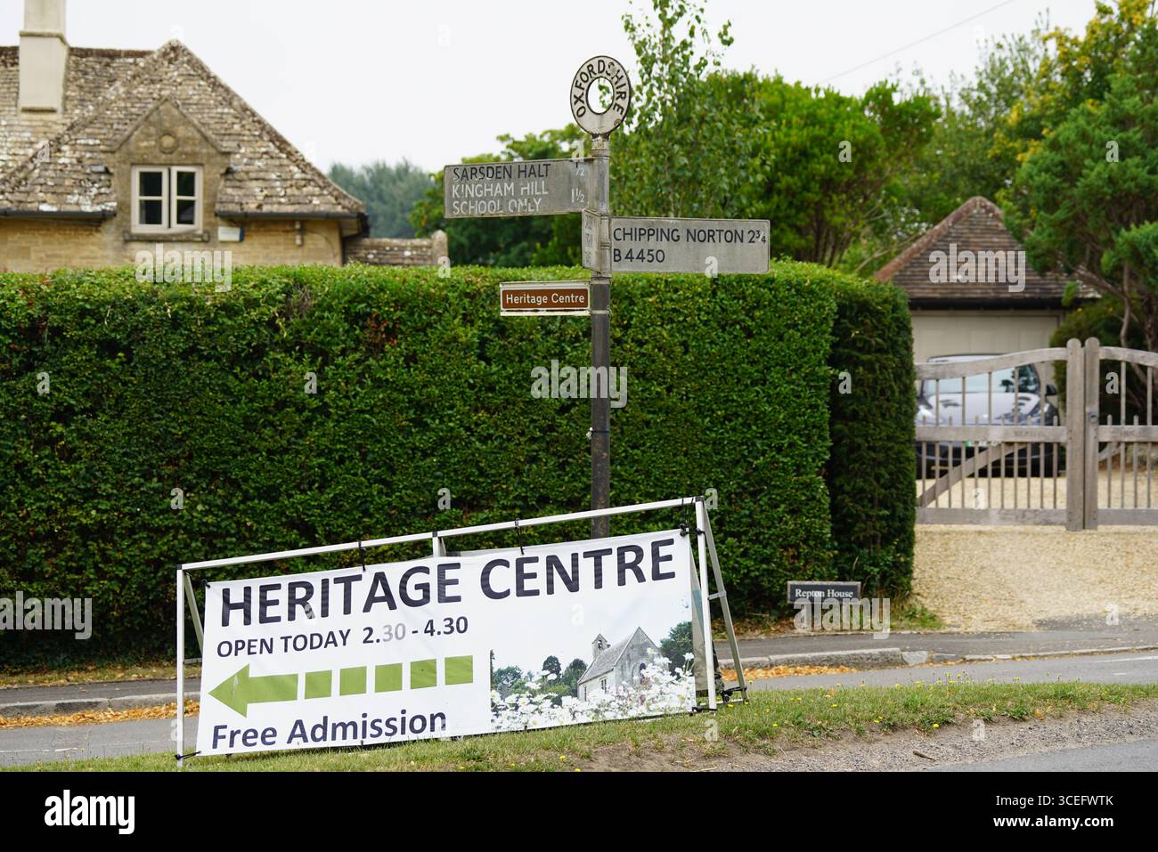 Cartello d'ingresso al Centro storico con sentiero rurale e tradizionale Casa in pietra. Churchill, Inghilterra Foto Stock