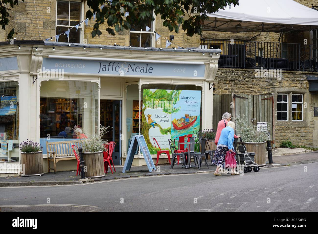 Affascinante libreria di campagna con posti a sedere all'aperto e pedoni per anziani. Chipping Norton, Inghilterra Foto Stock