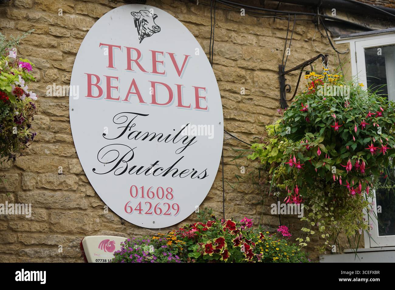 Cartello rustico per la macelleria per famiglie con decorazioni floreali. Chipping Norton, Inghilterra Foto Stock