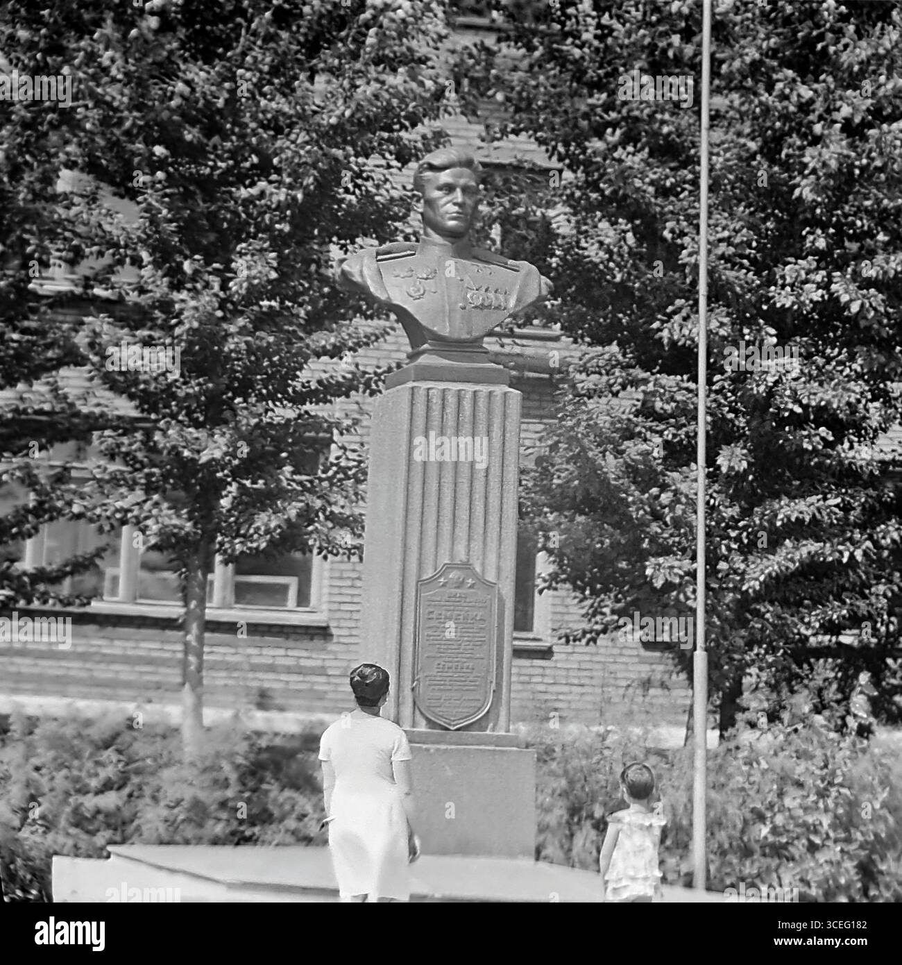 Foto d'archivio del monumento al pilota, due volte eroe dell'Unione Sovietica Nikolai Semeyko, a Sloviansk, RSS Ucraina, anni '1960 - '1970, con una madre e un bambino al busto dell'eroe, come simbolo di vita pacifica e di educazione patriottica prima della guerra Foto Stock