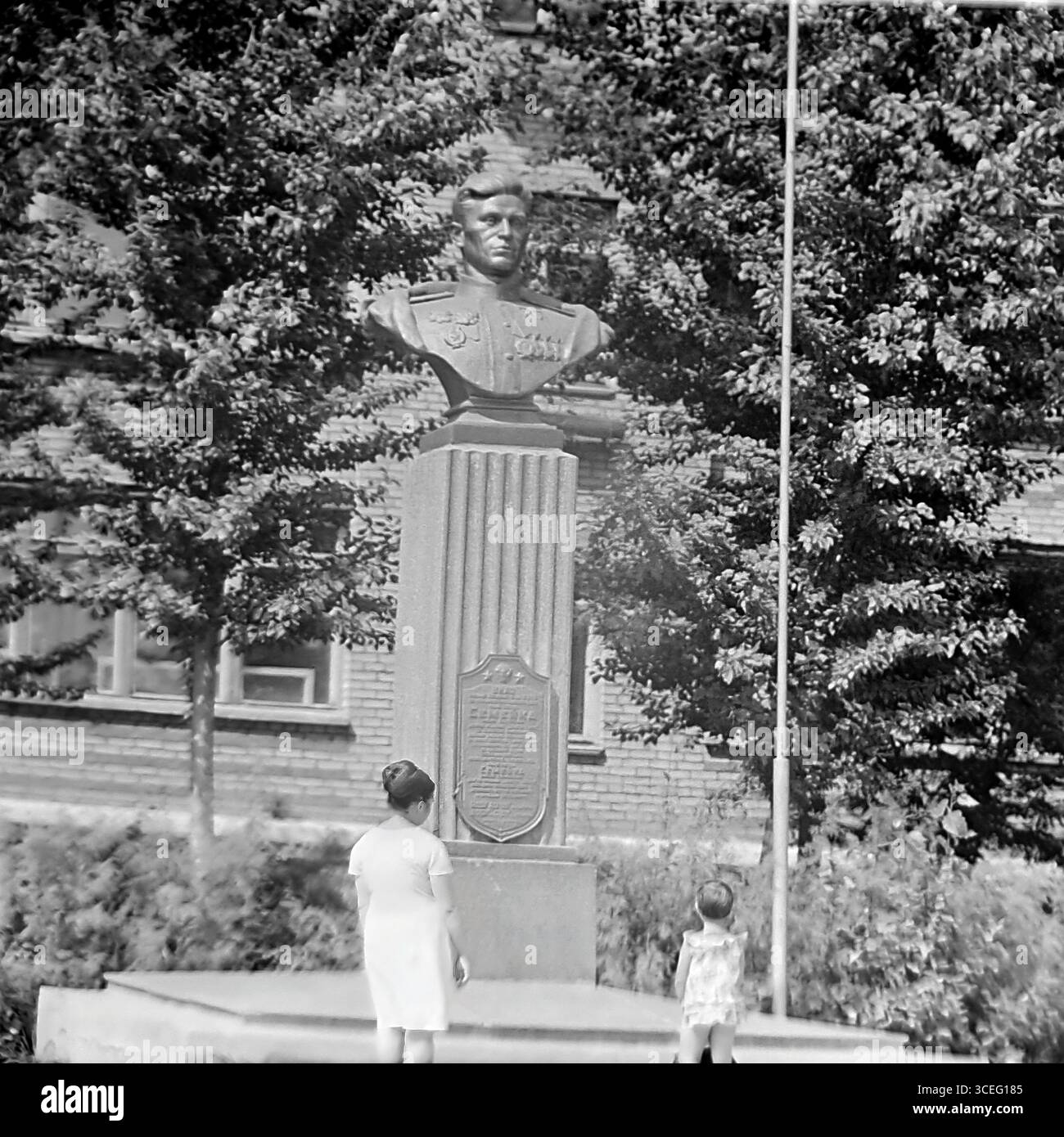 Foto d'archivio del monumento al pilota, due volte eroe dell'Unione Sovietica Nikolai Semeyko, a Sloviansk, RSS Ucraina, anni '1960 - '1970, con una madre e un bambino al busto dell'eroe, come simbolo di vita pacifica e di educazione patriottica prima della guerra Foto Stock