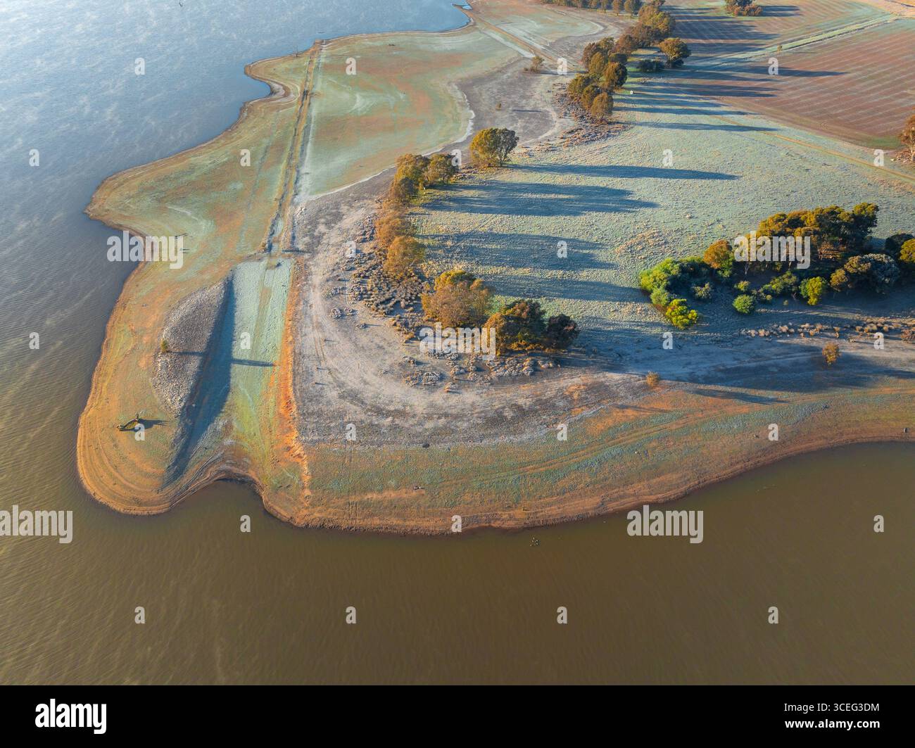 Veduta aerea di lunghe ombre e gelo che coprono una massa di terra che si protende nel Cairn Curran Reservoir, Joyces Creek nel Victoria centrale, Australia. Foto Stock