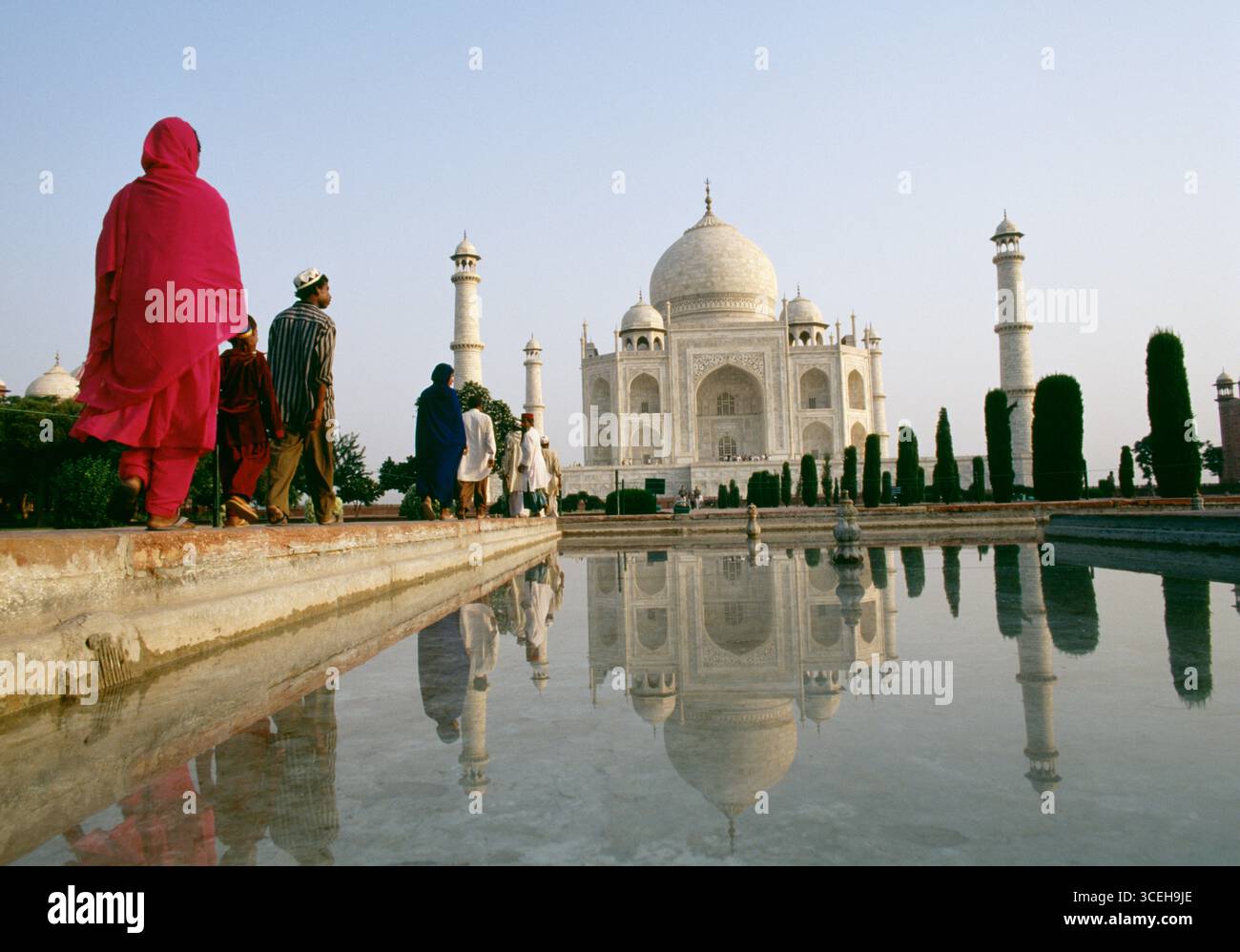I visitatori camminano verso il Taj Mahal, uno dei monumenti più famosi in India e in tutto il mondo. Gruppo medio di oggetti, una persona, una donna, Rosso Foto Stock