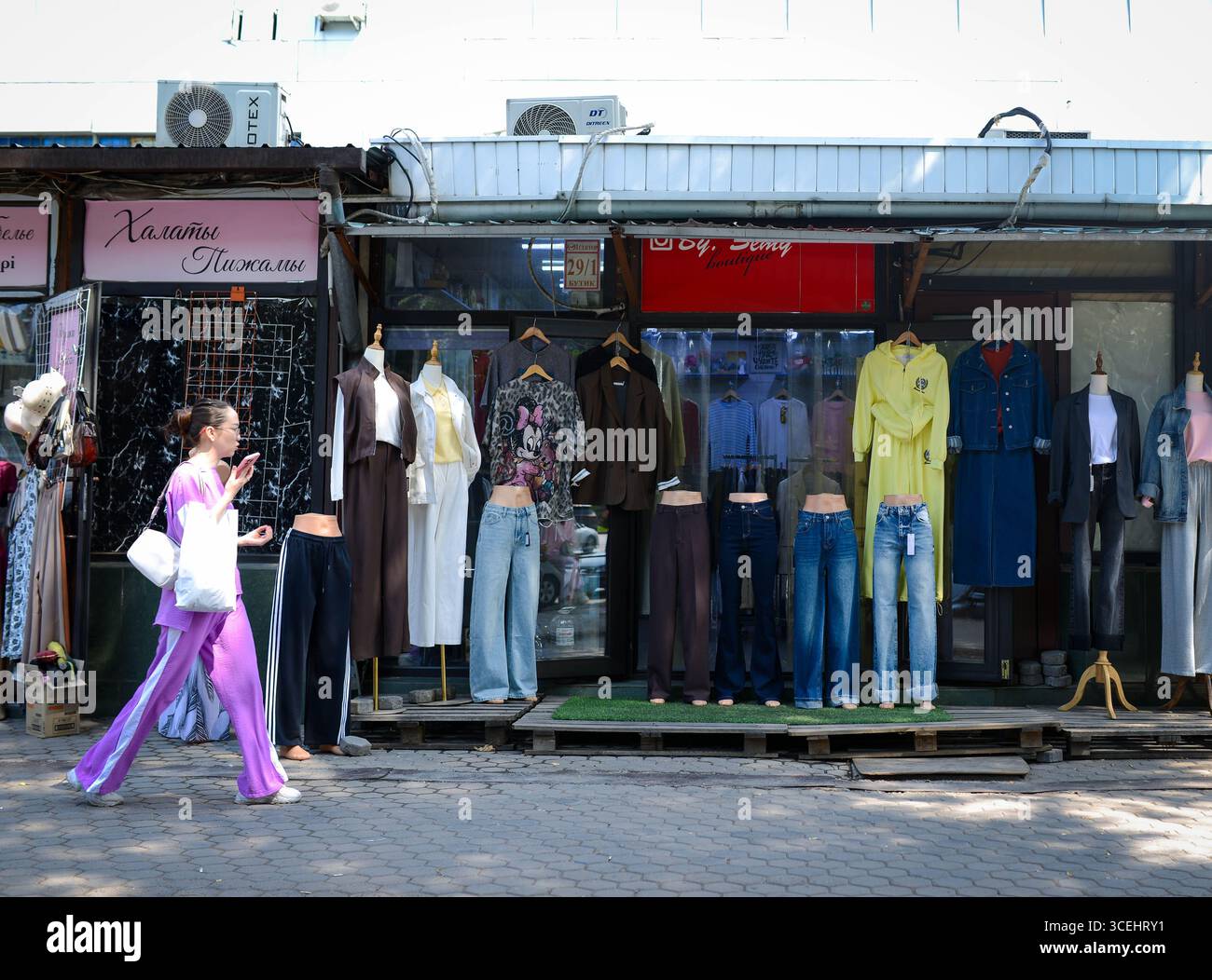 Almaty, Kazakistan. 17 agosto 2025. Una donna passa da un negozio di abbigliamento nel centro di Almaty, Kazakistan, il 17 agosto 2025. Il prodotto interno lordo (PIL) del Kazakistan è cresciuto del 6,3% su base annua nel periodo gennaio-luglio 2025, ha detto martedì il Ministero dell'economia nazionale. Crediti: Li Renzi/Xinhua/Alamy Live News Foto Stock