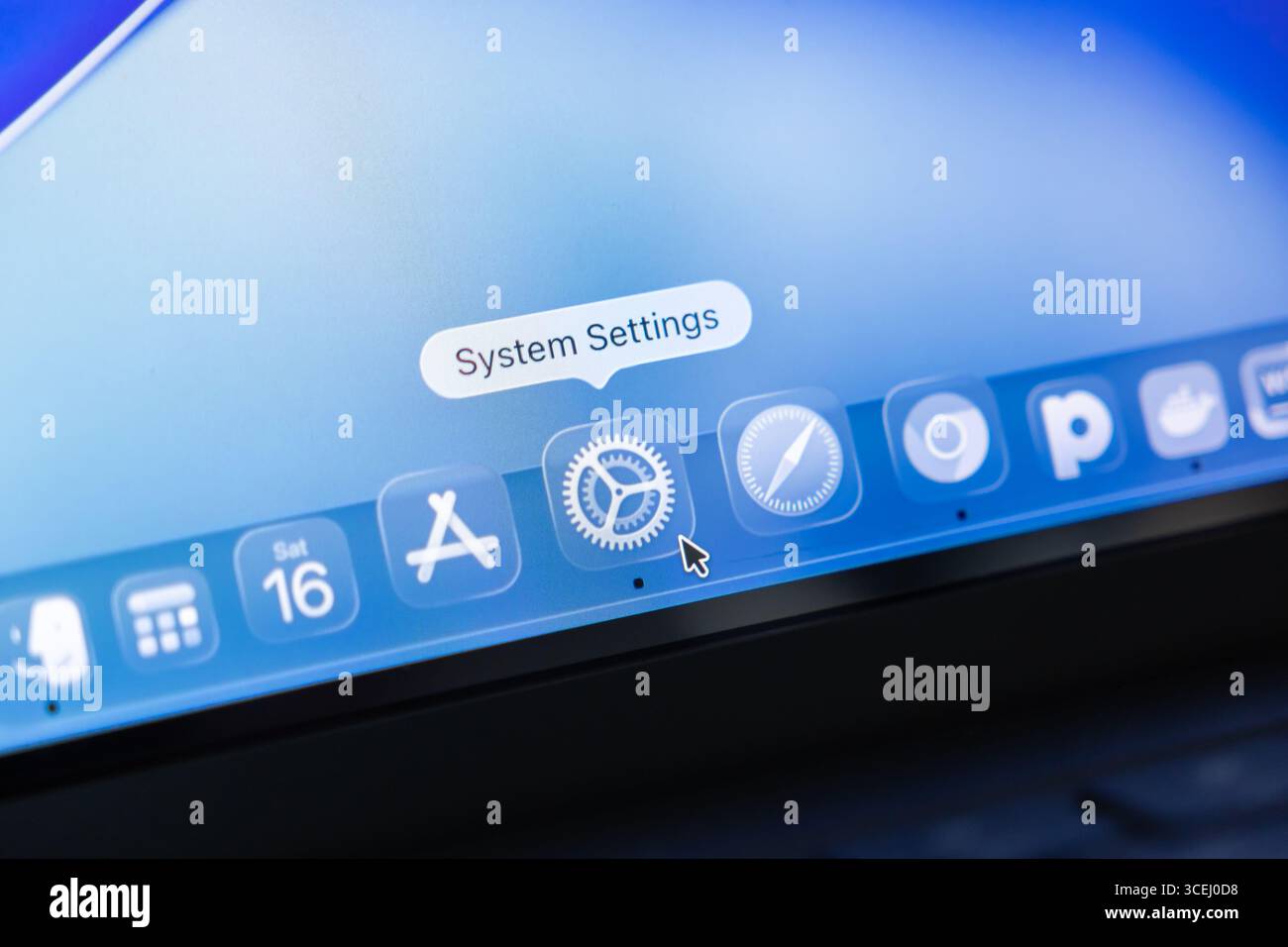 Poznan, Polonia - 15 agosto 2025: Vista ravvicinata del desktop macOS 26, con icone delle applicazioni in vetro liquido traslucido e puntatore su System se Foto Stock