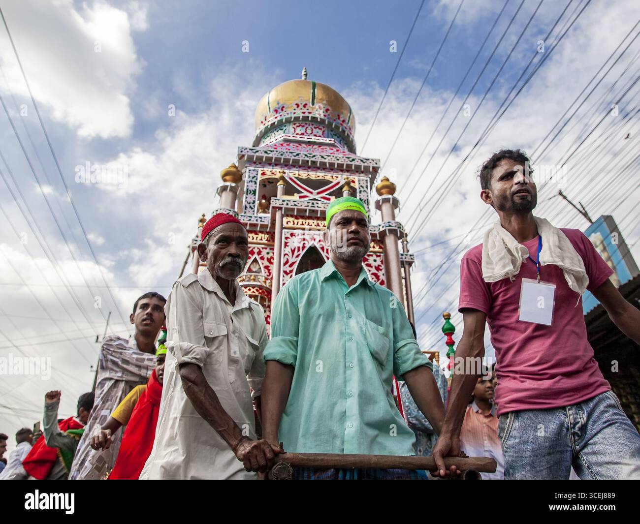 Chattogram, Bangladesh - 29 luglio 2023: Veduta di una processione religiosa con un galleggiante di Tazia decorato in modo luminoso che taglia una figura vibrante contro il cielo nuvoloso. Foto Stock