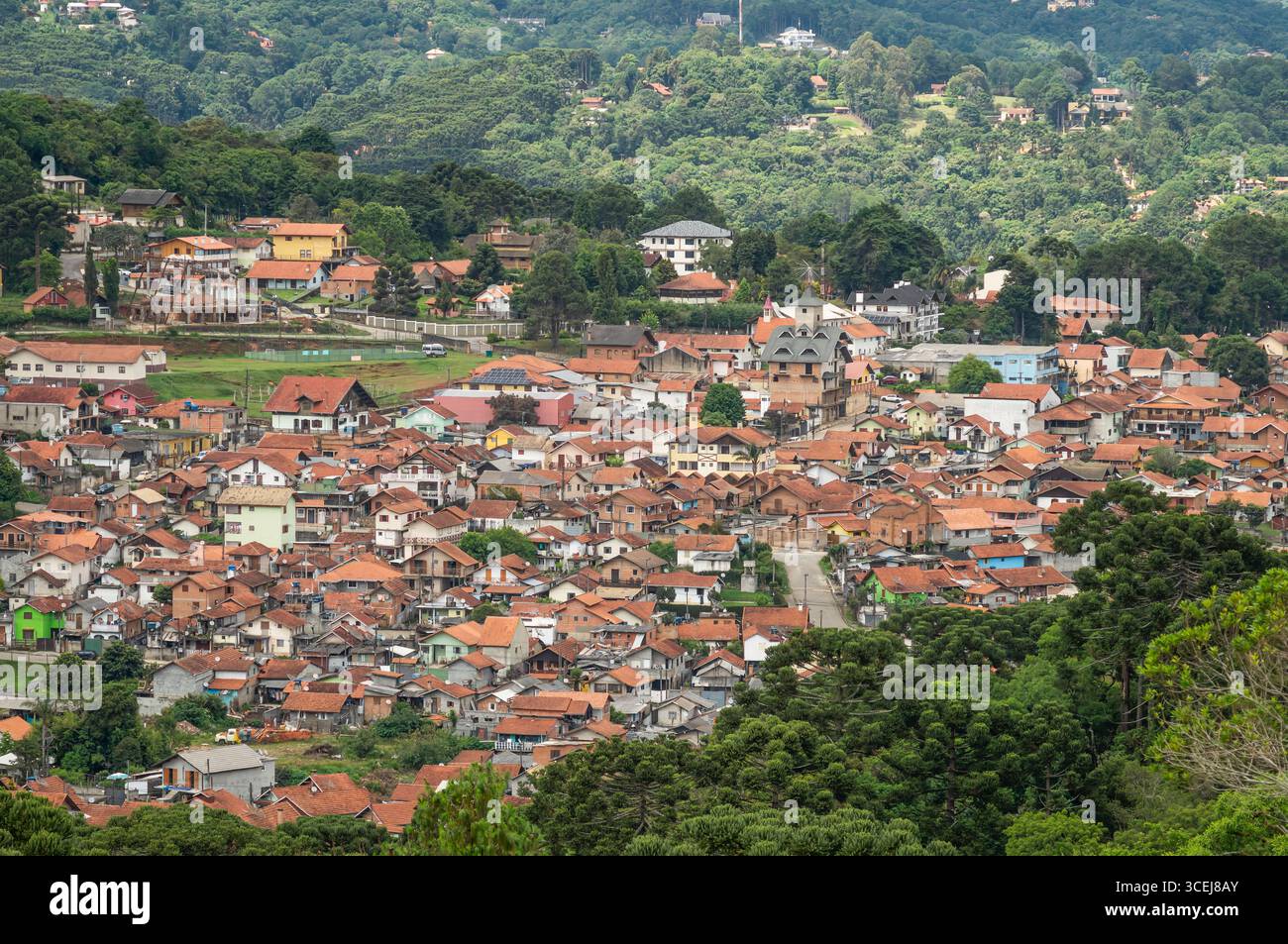 Vista panoramica della località turistica di Monte Verde, immersa in una lussureggiante valle verde con fitte foreste e case tradizionali in una mattina d'estate. Foto Stock