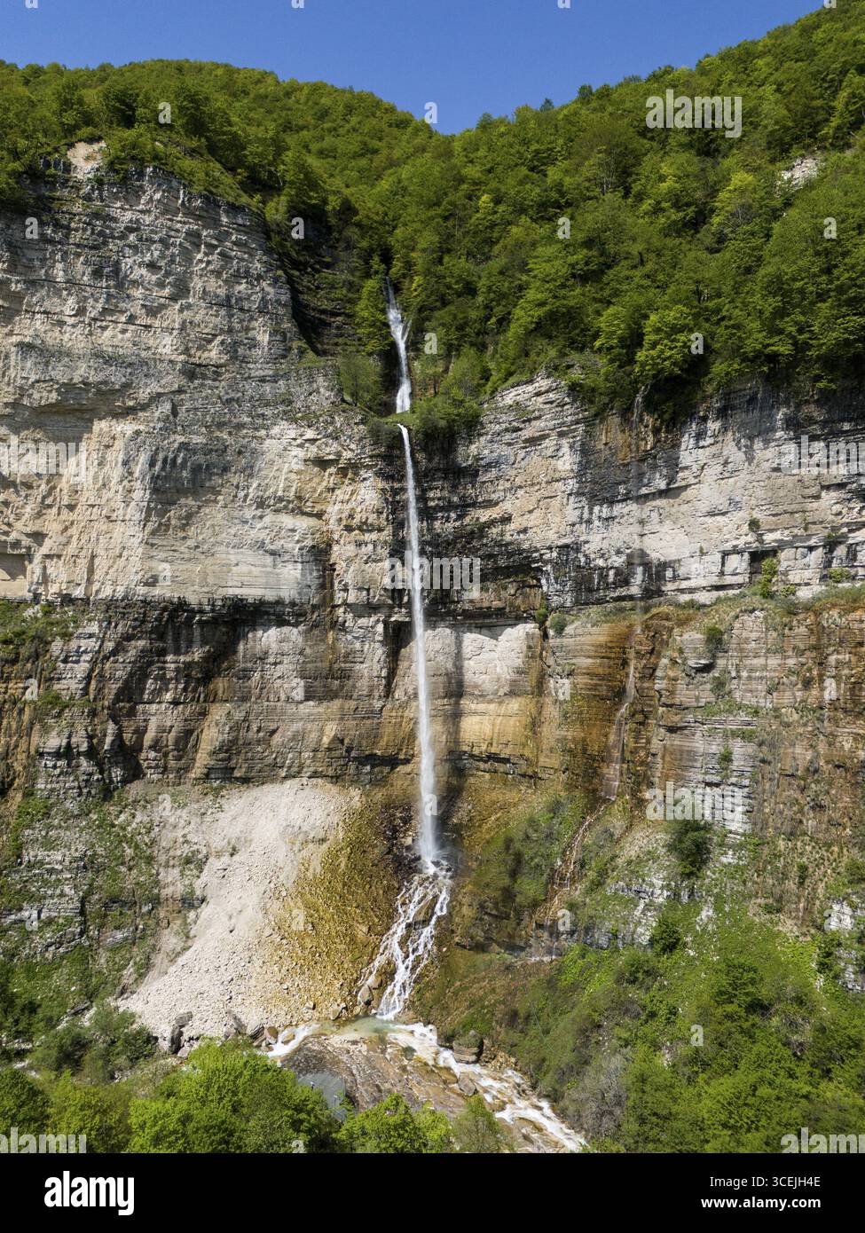 La sublime cascata scorre lungo una ripida parete rocciosa, circondata da fitto verde, vista aerea, cascata Okatse, Kinchkha, cascata in tre fasi, Sats Foto Stock