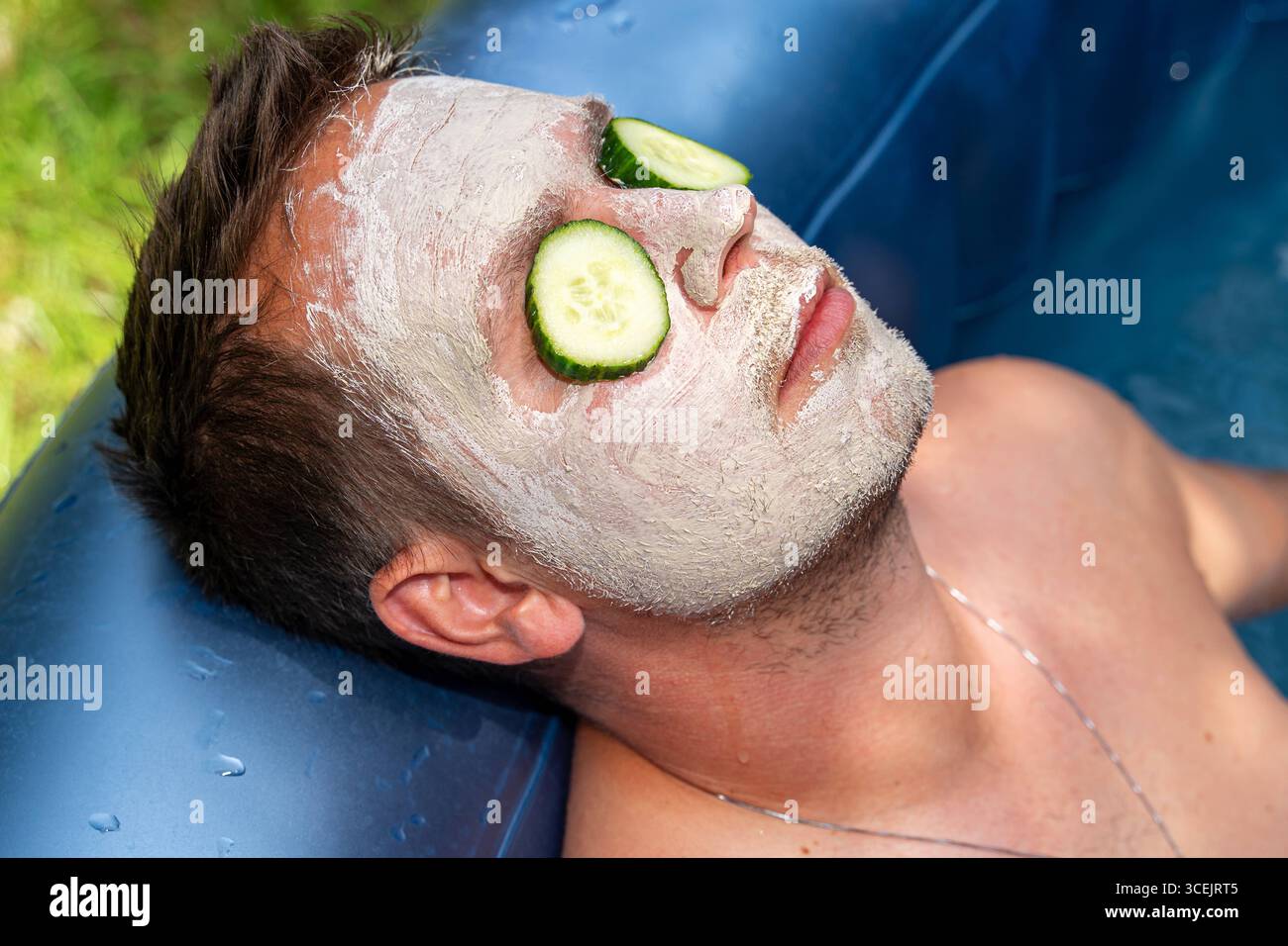 Baviera, Germania 18 agosto 2025: Cura naturale della pelle con cetrioli e maschere di fango benessere in armonia con la natura. L'immagine mostra rilassamento, cosmetici sostenibili e cura consapevole di sé per gli uomini. *** Natürliche Hautpflege mit Gurken und Gesichtsmaske aus Schlamm Wellness im Einklang mit der Natur. DAS Bild zeigt Entspannung, nachhaltige Kosmetik und bewusste Selbstfürsorge bei Männern. Foto Stock