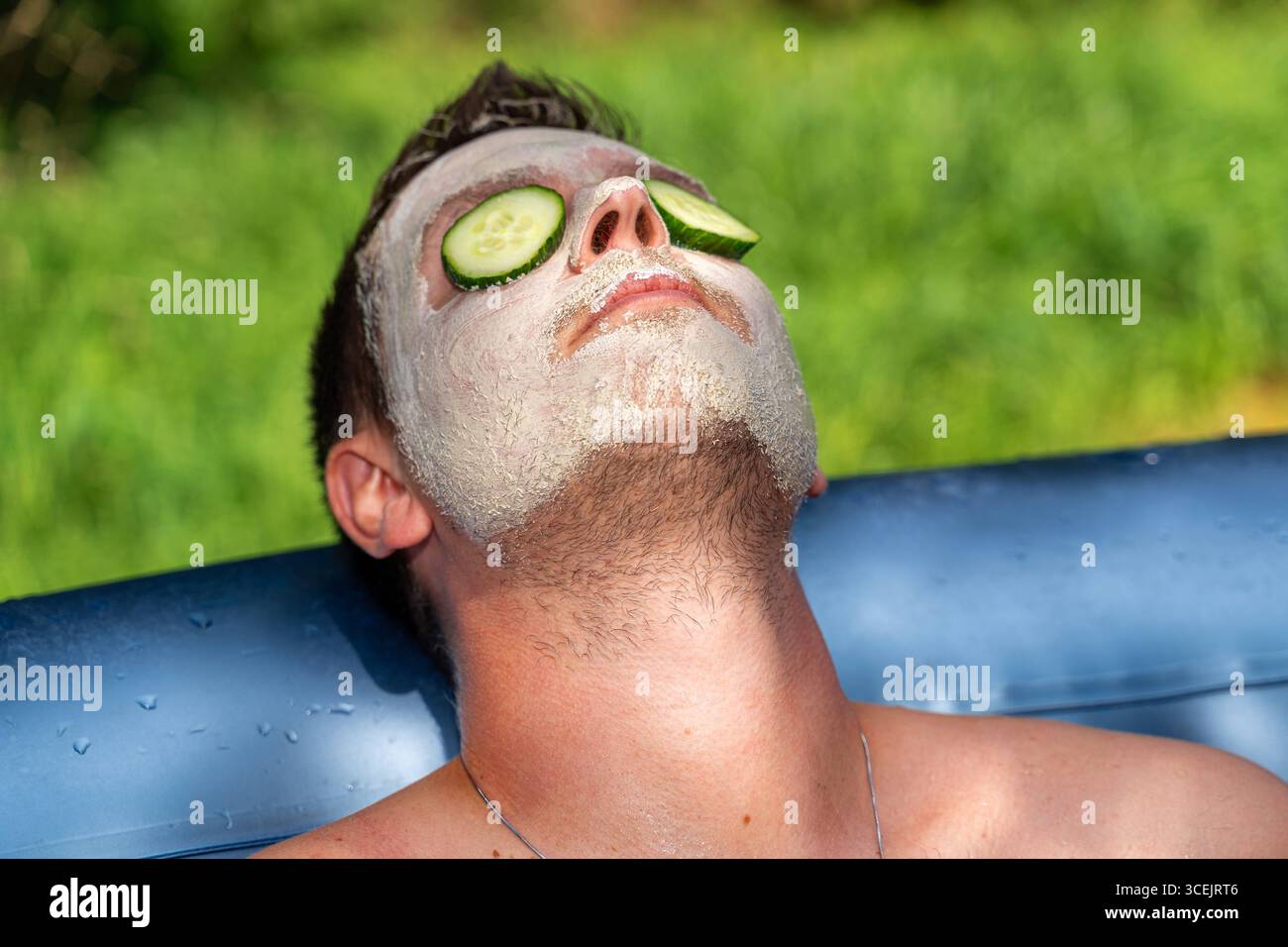 Baviera, Germania 18 agosto 2025: Cura naturale della pelle con cetrioli e maschere di fango benessere in armonia con la natura. L'immagine mostra rilassamento, cosmetici sostenibili e cura consapevole di sé per gli uomini. *** Natürliche Hautpflege mit Gurken und Gesichtsmaske aus Schlamm Wellness im Einklang mit der Natur. DAS Bild zeigt Entspannung, nachhaltige Kosmetik und bewusste Selbstfürsorge bei Männern. Foto Stock