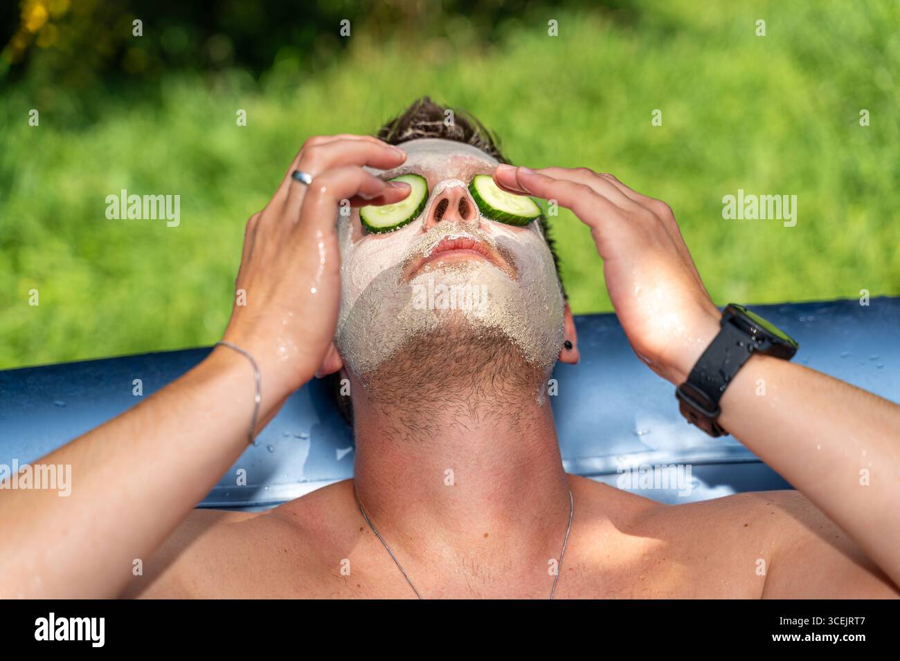 Baviera, Germania - 18 agosto 2025: Benessere e relax a casa cura naturale della pelle con cetrioli e maschere per il relax e la freschezza nella vita di tutti i giorni. *** Wellness und Entspannung ganz einfach zuhause natürliche Hautpflege mit Gurken und Maske sorgt für Erholung und Frische im Alltag. Foto Stock