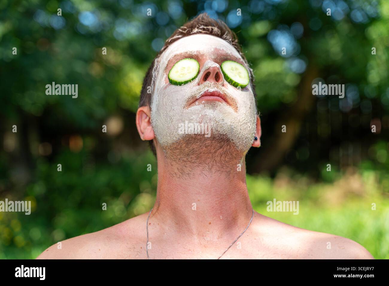 Baviera, Germania 18 agosto 2025: Cura naturale della pelle con cetrioli e maschere di fango benessere in armonia con la natura. L'immagine mostra rilassamento, cosmetici sostenibili e cura consapevole di sé per gli uomini. *** Natürliche Hautpflege mit Gurken und Gesichtsmaske aus Schlamm Wellness im Einklang mit der Natur. DAS Bild zeigt Entspannung, nachhaltige Kosmetik und bewusste Selbstfürsorge bei Männern. Foto Stock