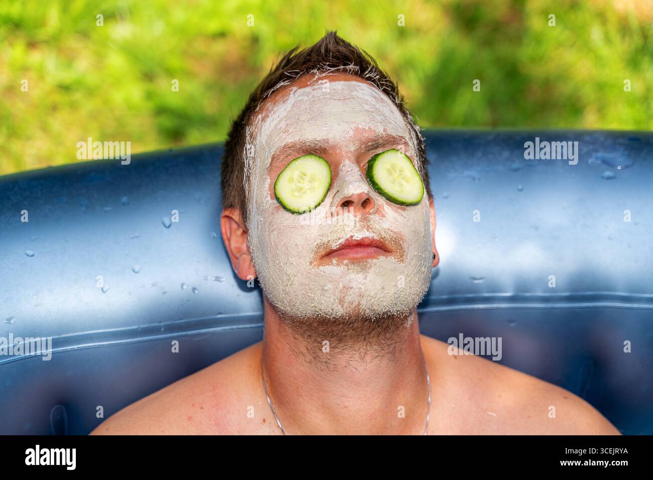 Baviera, Germania 18 agosto 2025: Cura naturale della pelle con cetrioli e maschere di fango benessere in armonia con la natura. L'immagine mostra rilassamento, cosmetici sostenibili e cura consapevole di sé per gli uomini. *** Natürliche Hautpflege mit Gurken und Gesichtsmaske aus Schlamm Wellness im Einklang mit der Natur. DAS Bild zeigt Entspannung, nachhaltige Kosmetik und bewusste Selbstfürsorge bei Männern. Foto Stock