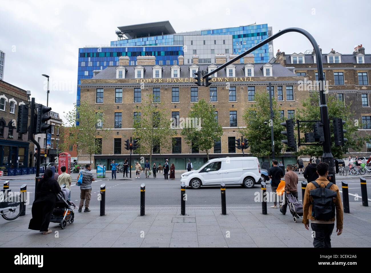 L'architettura esterna blu del Royal London Hospital si è vista apparire sopra il vecchio ospedale, ora Tower Hamlets Town Hall a Whitechapel il 4 agosto 2025 a Londra, Regno Unito. Il più grande nuovo ospedale della Britannia, il Royal London and Barts, nuovo edificio all'avanguardia che si trova dietro lo storico blocco frontale che si affaccia su Whitechapel. Questa struttura in vetro blu è massiccia in scala e rappresenta una moderna testimonianza architettonica del NHS. Foto Stock