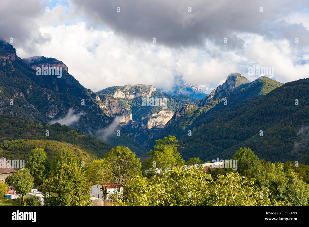 Vista panoramica da Asín de Broto, che mostra scogliere spettacolari, fitte foreste e cime nebbiose della valle di Ordesa nei Pirenei, Aragona, Spagna. Foto Stock