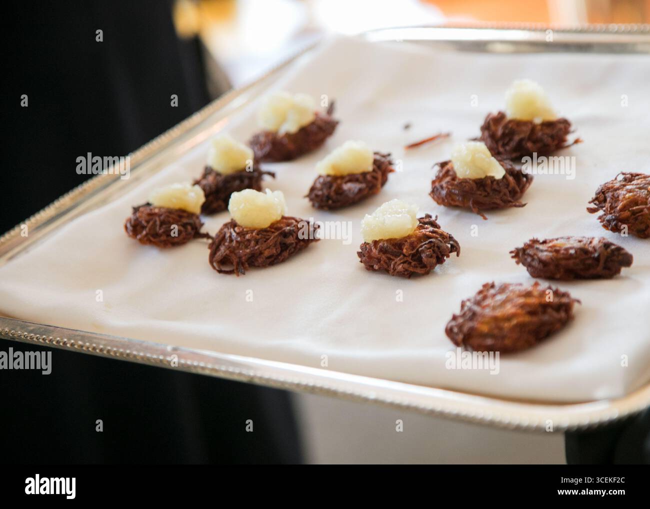 Delicati nidi di patate dolci preparati ad arte con panna, che mettono in mostra la creatività gourmet in un evento culinario. Foto Stock