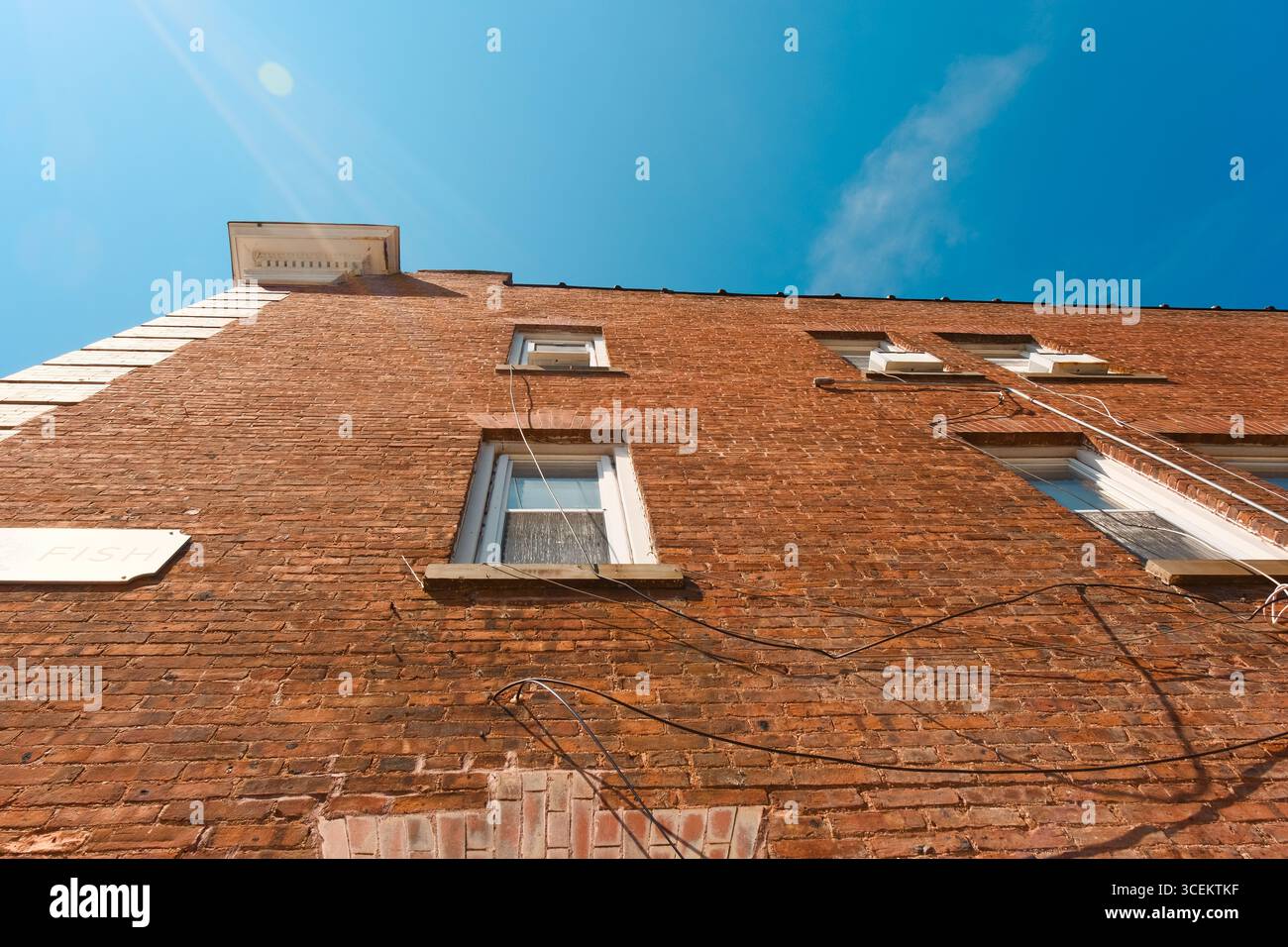 Affacciato su un vecchio edificio in mattoni dal cielo blu brillante Foto Stock Affacciato su un vecchio edificio in mattoni dal cielo blu brillante Foto Stock