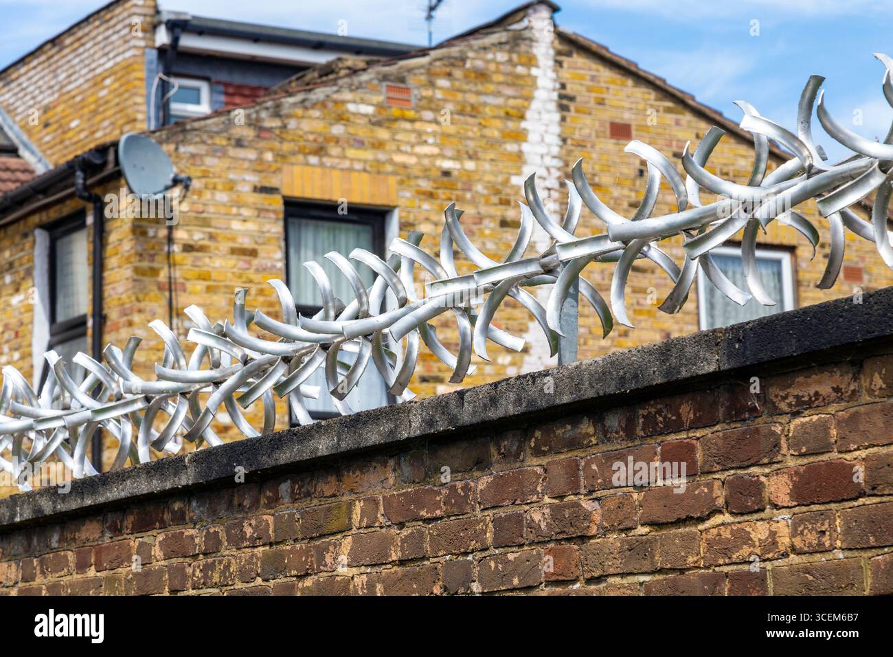 Picchi di protezione anti-salita e antifurto in metallo su un muro a Londra, Inghilterra Foto Stock