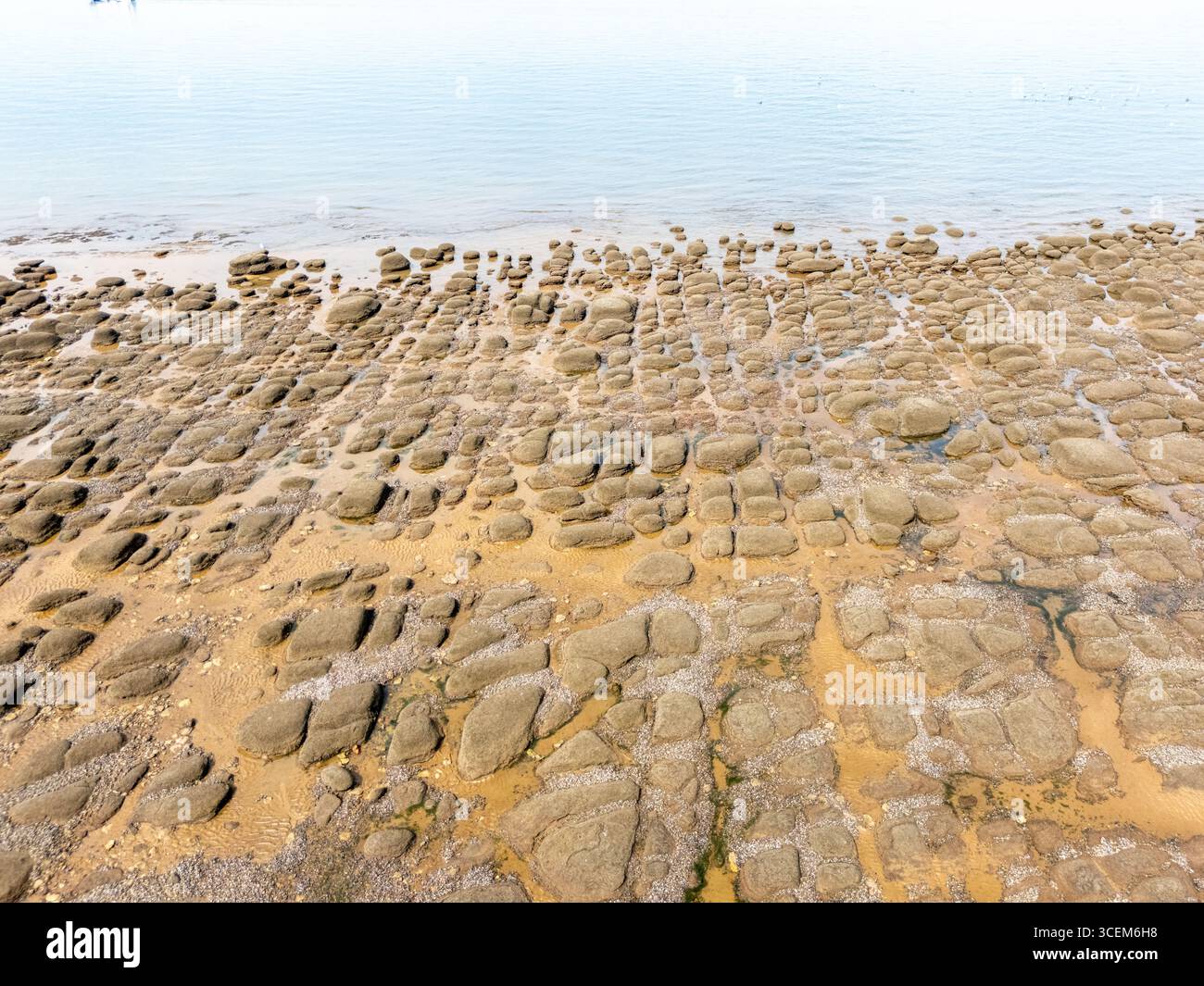 Vista aerea che guarda in basso sulle piscine rocciose della spiaggia di Hunstanton nel Norfolk mentre le onde si infrangono dolcemente. Foto Stock