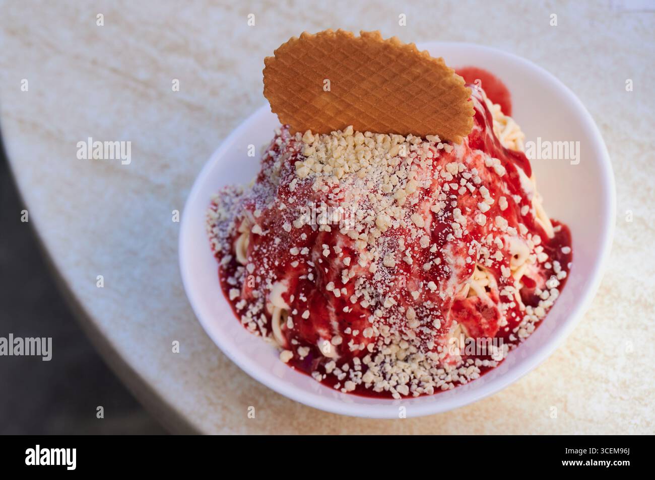 Dessert tradizionale tedesco con gelato alla vaniglia, servito con salsa di fragole e grattugiato Foto Stock