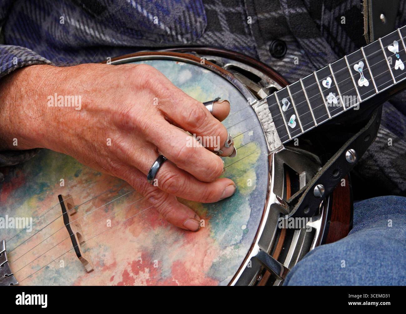 Le dita artritiche di un uomo e scegli le corde su un banjo mentre intrattieni la folla in una fiera di campagna nell'Oregon centrale, vicino alla città di Sisters Foto Stock