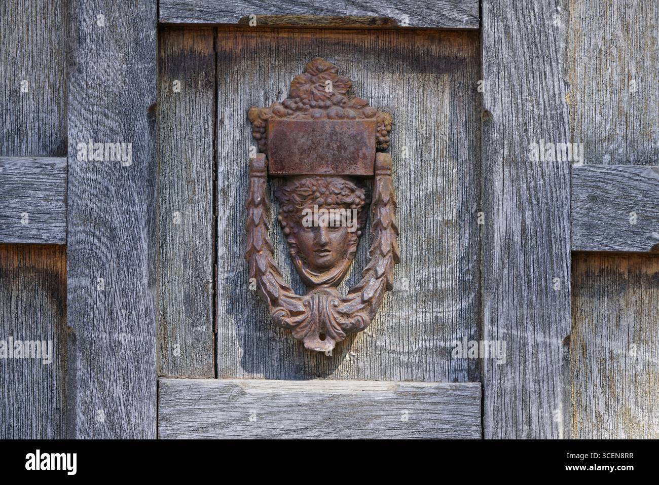 Battitacco porta in ferro rustico su Una superficie in legno resistente agli agenti atmosferici. Deddington, Inghilterra Foto Stock