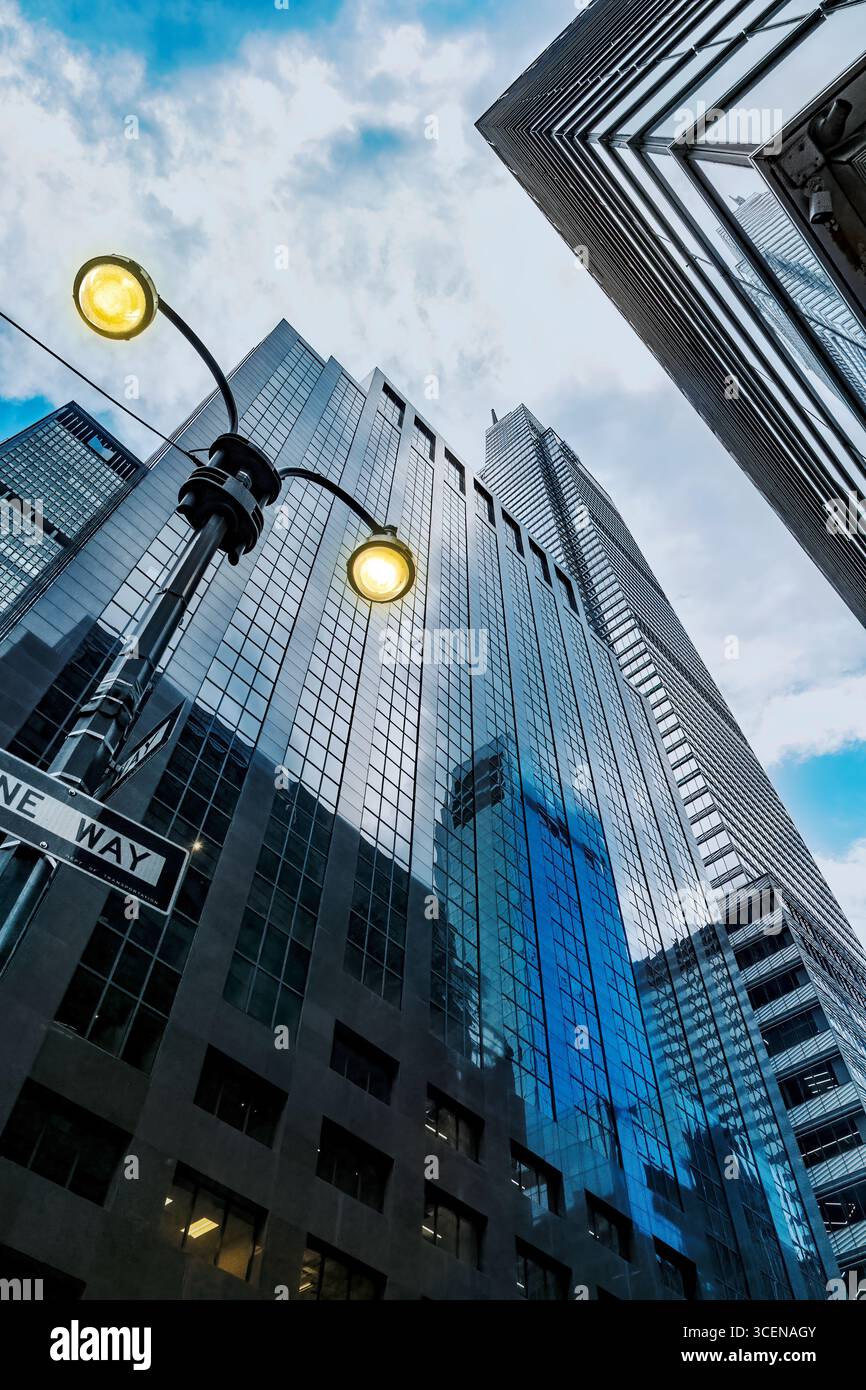 New York, Manhattan in centro. grattacieli con illuminazione stradale. Guardando in alto. Foto Stock