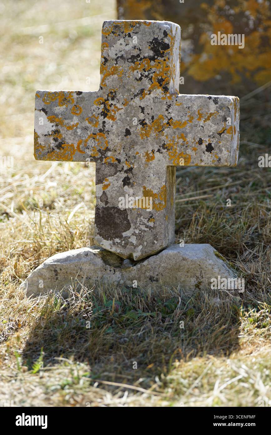 Croce di pietra con muschio in un ambiente naturale illuminato dal sole. Adderbury, Inghilterra Foto Stock
