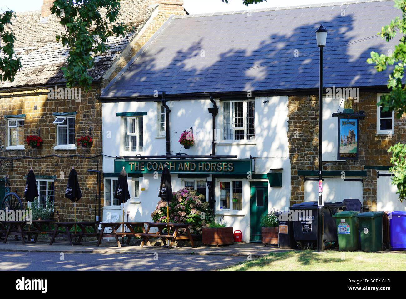 Storico Country Pub con posti a sedere all'aperto il giorno della domenica. Adderbury, Inghilterra Foto Stock