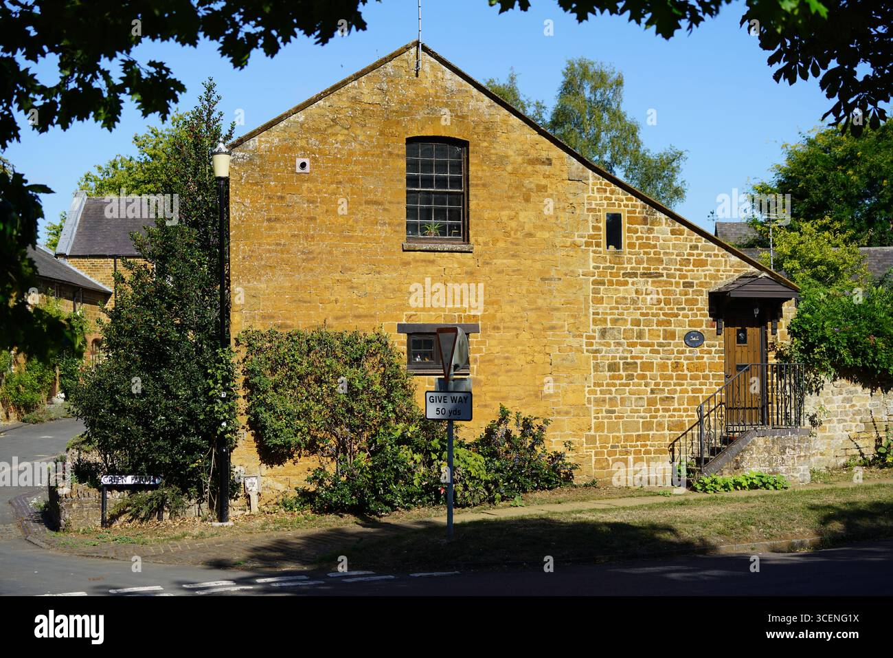Edificio tradizionale in pietra in una tranquilla area residenziale con area naturale soleggiata. Adderbury, Inghilterra Foto Stock