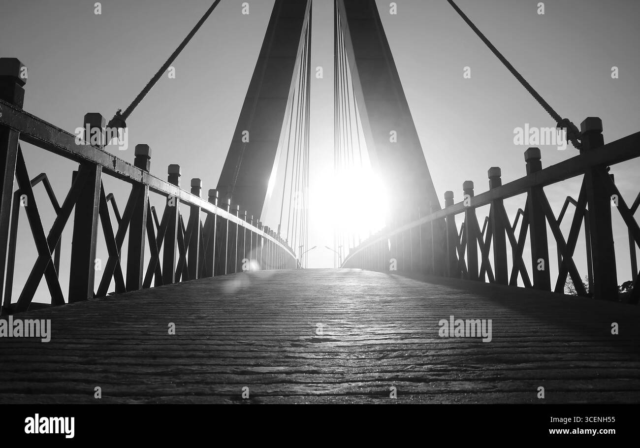 Sagoma architettonica del ponte sospeso che raggiunge la luce solare Foto Stock