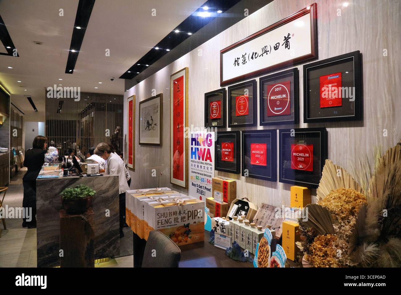 SINGAPORE, SINGAPORE - 11 MARZO 2024: Più premi Michelin Star esposti all'interno del ristorante Putien nella città di Singapore. Foto Stock