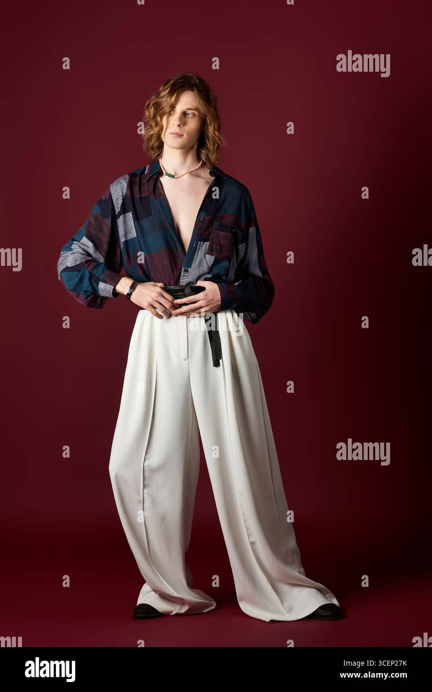 Questo bell'uomo, che presenta un outfit audace, trasuda fiducia e stile di tendenza. Foto Stock