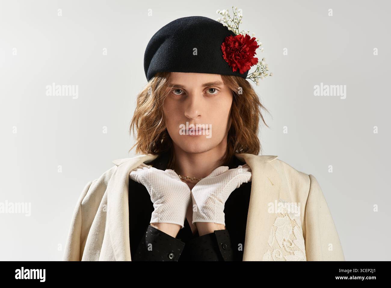 Un uomo giovane trasuda fascino ed eleganza con una scelta di moda sorprendente, che mette in risalto il suo fascino. Foto Stock