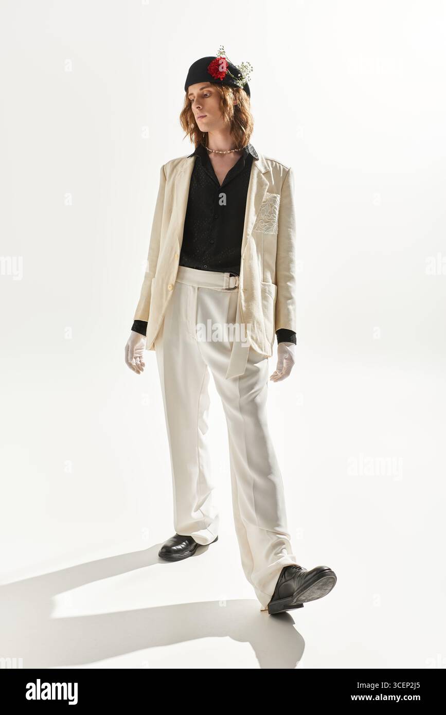 Un giovane straordinario sfoggia il suo stile unico in un outfit elegante e sicuro di sé. Foto Stock