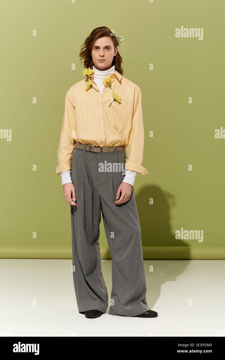 Un giovane e affascinante uomo con un abbigliamento oversize si distingue con fiducia, incarnando lo stile femminile e di tendenza. Foto Stock