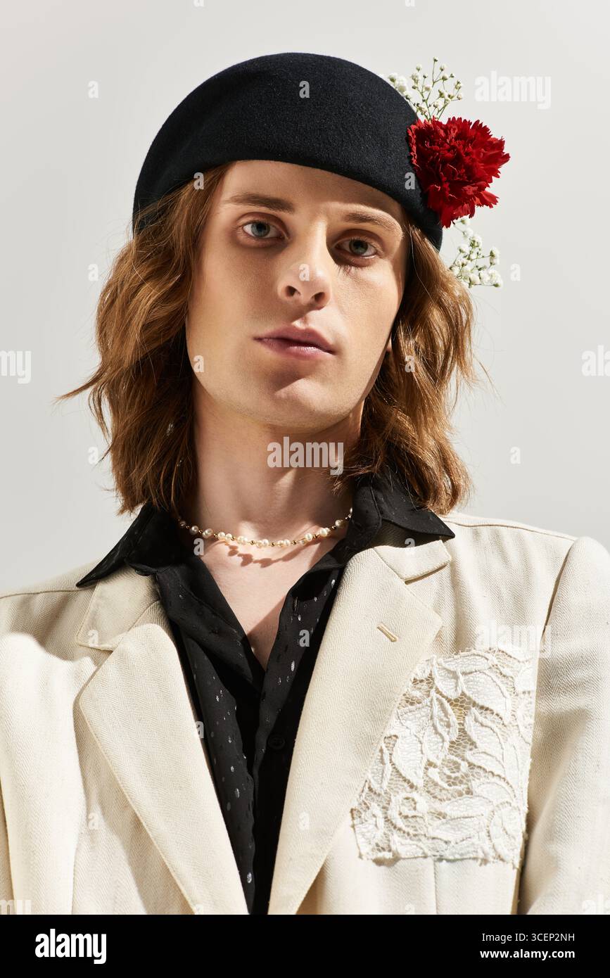 Un giovane uomo con un mix unico di moda femminile si distingue con fiducia, adornato da accessori. Foto Stock