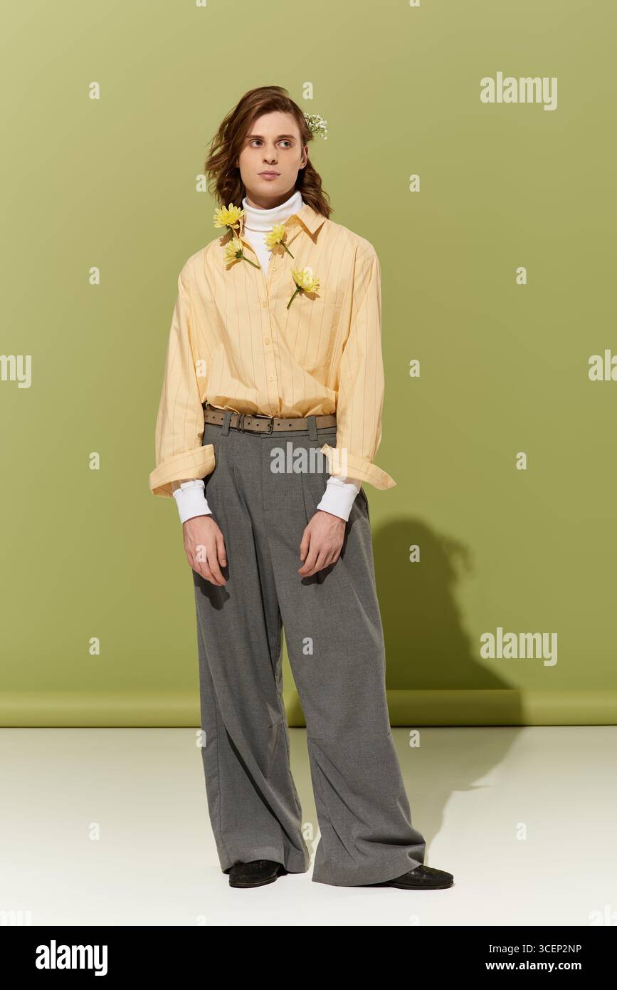 Un giovane uomo presenta un mix unico di stile femminile e moda moderna in un'atmosfera vivace. Foto Stock