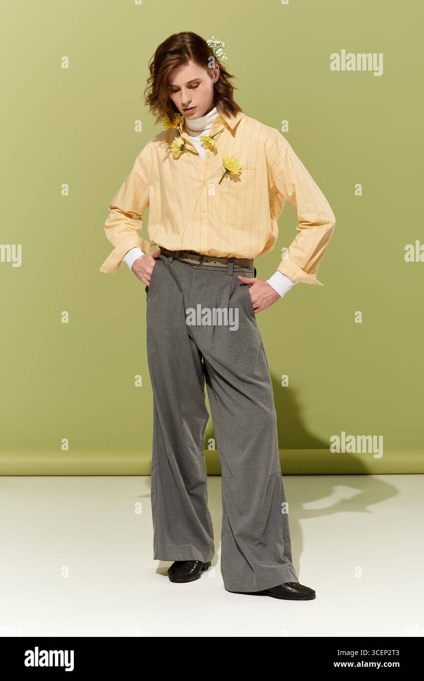 Un giovane sicuro di sé con camicia color pastello e pantaloni ampi, impreziositi da fiori. Foto Stock