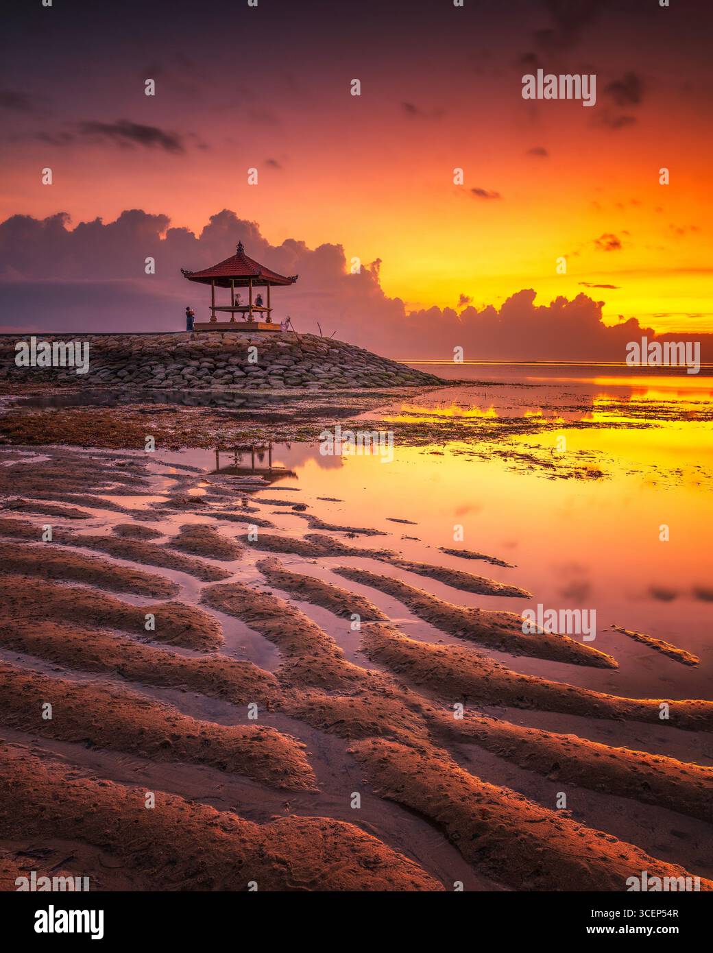 Mentre il sole sorge all'orizzonte, il Pantai Sanur di Bali si trasforma in uno spettacolo mozzafiato. Foto Stock
