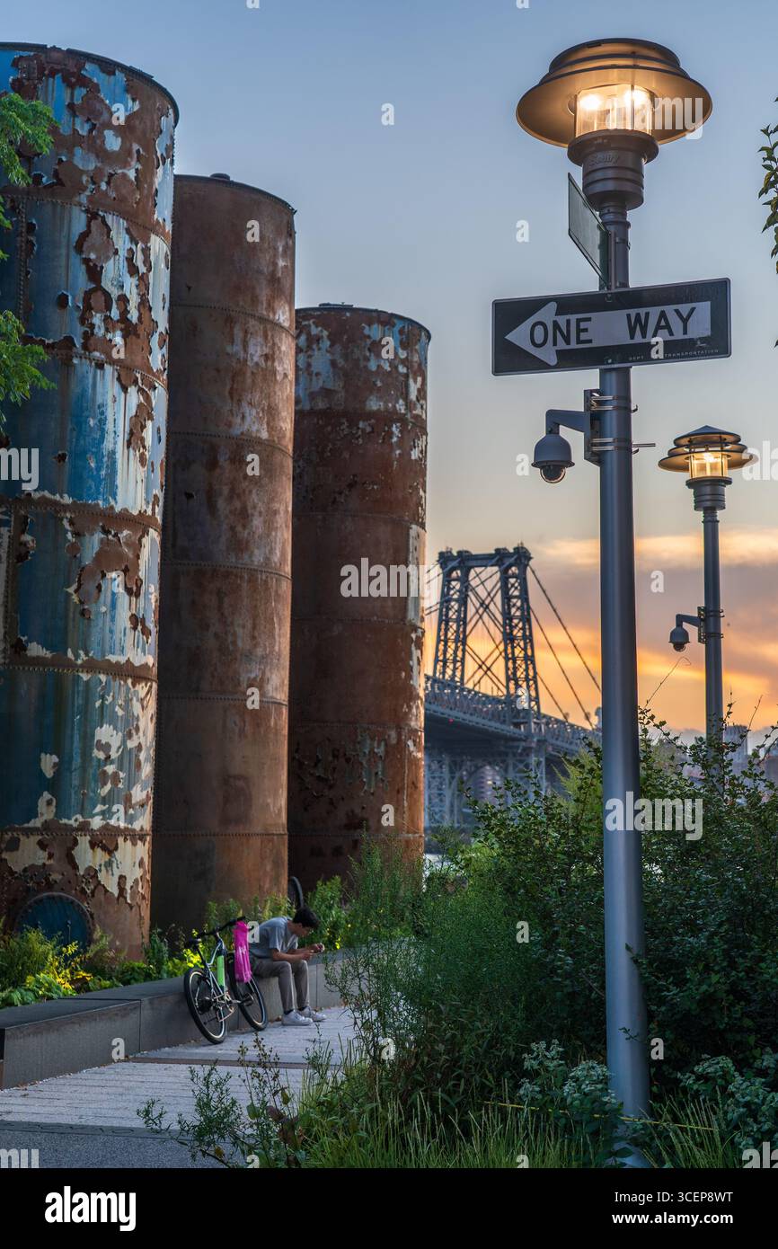 Domino Park, Brooklyn, Stati Uniti - 12 agosto 2025: Vista dei silos arrugginiti che si ergono alti sullo sfondo del Williamsburg Bridge, come po chiaro Foto Stock
